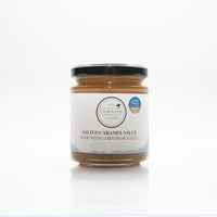 A jar of salted caramel sauce with cornish sea salt on a white background