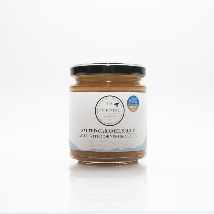 A jar of salted caramel sauce with cornish sea salt on a white background