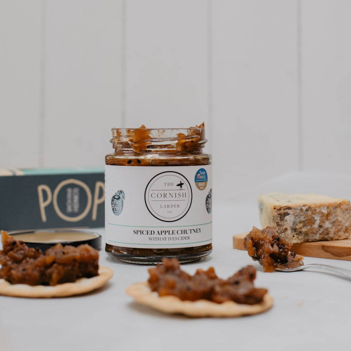 apple chutney jar with chutney on crackers in front of the jar