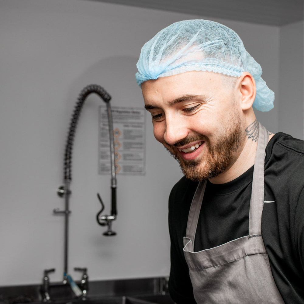 Person in a kitchen wearing gloves and an apron